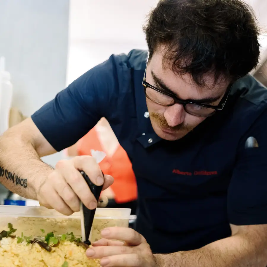 Un alumne de cuina treballa concentrat en la preparació d'un plat